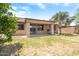 View of backyard with covered patio, lush tree, grass, and block fence at 12089 N 145Th Dr, Surprise, AZ 85379