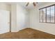 Bedroom features neutral carpet, a ceiling fan, a window with blinds, and a closet with sliding doors at 12089 N 145Th Dr, Surprise, AZ 85379