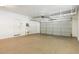 Spacious garage featuring a service door, utility sink, and an automatic garage door at 12089 N 145Th Dr, Surprise, AZ 85379
