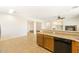 Kitchen has wooden cabinets, bar seating, and a black dishwasher with an open floorplan at 12089 N 145Th Dr, Surprise, AZ 85379
