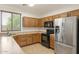Well-lit kitchen features wood cabinets, stainless steel refrigerator, black oven, and microwave at 12089 N 145Th Dr, Surprise, AZ 85379