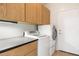 Laundry room with washer, dryer, counter space, and wood cabinets for storage at 12089 N 145Th Dr, Surprise, AZ 85379