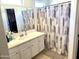 Bathroom featuring a white vanity with a large mirror and a shower with a patterned curtain for privacy at 1350 S Greenfield Rd # 2231, Mesa, AZ 85206