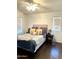 Cozy bedroom features a ceiling fan, window with blinds, and a comfortable bed with decorative pillows and striped bedding at 1350 S Greenfield Rd # 2231, Mesa, AZ 85206