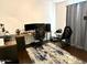 A room with a desk, computer, chair and gaming console on an area rug in a room with neutral walls at 1350 S Greenfield Rd # 2231, Mesa, AZ 85206