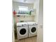 Functional laundry room with a full-sized washer and dryer, with shelving, offering convenience and space-saving storage at 1350 S Greenfield Rd # 2231, Mesa, AZ 85206