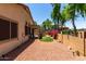 Charming backyard features low-maintenance desert landscaping, a small artificial lawn area, and privacy fence with beautiful flowers at 14314 W Lexington Ave, Goodyear, AZ 85395
