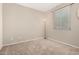 This bedroom has neutral walls and carpeting with natural light and a large window at 14314 W Lexington Ave, Goodyear, AZ 85395