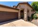 The front entrance of this lovely home boasts mature landscaping, a two-car garage, and a well-maintained driveway at 14314 W Lexington Ave, Goodyear, AZ 85395