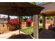 Covered patio area with an umbrella and brick pavers, overlooking a beautiful, private landscaped backyard at 14314 W Lexington Ave, Goodyear, AZ 85395