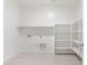 An efficiently designed laundry room with tile floors and built-in shelving at 1447 S 239Th Dr, Buckeye, AZ 85326