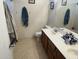 Bathroom with a double vanity, tiled floors, toilet and towel racks, offering a functional space at 14700 N El Frio St, El Mirage, AZ 85335