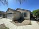 A charming single-story home with a two car garage and desert landscaping under a blue sky at 14700 N El Frio St, El Mirage, AZ 85335