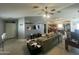 Spacious living room with a ceiling fan, grey wall, and view into the kitchen at 14700 N El Frio St, El Mirage, AZ 85335