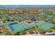Expansive aerial view of a community featuring tennis courts, lush landscaping, and multiple buildings at 16961 W Holly St, Goodyear, AZ 85395