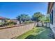 A charming enclosed backyard space features artificial turf, a stucco wall with brick trim, and a gate at 16961 W Holly St, Goodyear, AZ 85395