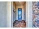Covered entryway featuring a decorative metal and glass front door, brick accents, and neutral paint at 16961 W Holly St, Goodyear, AZ 85395