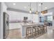 Bright kitchen with granite counters, stainless appliances, pendant lighting, and seating at the island at 16961 W Holly St, Goodyear, AZ 85395