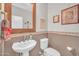 Cozy powder room featuring pedestal sink, toilet, and decorative wall decor at 16961 W Holly St, Goodyear, AZ 85395