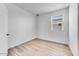 Bright bedroom featuring wood-look flooring, white walls, and a window with views at 18153 W Hiddenview Dr, Goodyear, AZ 85338