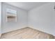 Well-lit room with wood-look flooring and a bright window featuring white blinds at 18153 W Hiddenview Dr, Goodyear, AZ 85338