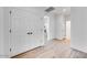 Hallway with double doors and wood-look flooring leading to other rooms at 18153 W Hiddenview Dr, Goodyear, AZ 85338