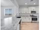 A bright kitchen with a granite island countertop, stainless steel appliances, and wood-look floors at 18153 W Hiddenview Dr, Goodyear, AZ 85338
