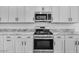 Well-equipped kitchen featuring stainless steel appliances, elegant granite countertops, and sleek white cabinetry at 18153 W Hiddenview Dr, Goodyear, AZ 85338