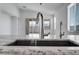 Close-up of kitchen sink featuring a modern faucet, granite countertops and an open, bright living space at 18153 W Hiddenview Dr, Goodyear, AZ 85338