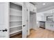 Walk-in pantry, white cabinets, stainless appliances, and wood-look flooring provide a functional kitchen layout at 18153 W Hiddenview Dr, Goodyear, AZ 85338
