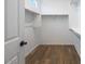 Spacious walk-in closet featuring custom shelving, hanging rods, and wood-look flooring at 18153 W Hiddenview Dr, Goodyear, AZ 85338