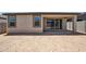 A covered back patio features neutral stucco and sliding glass doors to the home's interior at 18248 W La Senda Dr, Surprise, AZ 85387