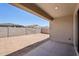 View of backyard featuring block fence and a covered patio with access to the home through a sliding glass door at 18248 W La Senda Dr, Surprise, AZ 85387
