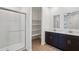 Modern bathroom featuring a glass-enclosed shower, built in shelves, and double vanity with dark wood cabinets at 18248 W La Senda Dr, Surprise, AZ 85387