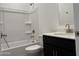 Well-lit bathroom with shower-tub combo and single sink with dark vanity at 18248 W La Senda Dr, Surprise, AZ 85387