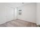 Bedroom with a double door closet, neutral carpet, and a bright window at 18248 W La Senda Dr, Surprise, AZ 85387