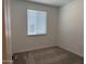 Cozy bedroom with neutral carpet, a window with blinds, and fresh white paint at 18248 W La Senda Dr, Surprise, AZ 85387