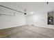 Spacious garage featuring white walls and a light gray floor with a back door to the backyard at 18248 W La Senda Dr, Surprise, AZ 85387