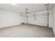 Spacious garage featuring white walls and a light gray floor with the garage door open at 18248 W La Senda Dr, Surprise, AZ 85387
