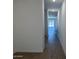 Bright hallway with wood-look tile flooring and recessed lighting leading towards a sliding glass door at 18248 W La Senda Dr, Surprise, AZ 85387