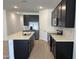 Modern kitchen with dark cabinets, white countertops, stainless steel appliances, and tile backsplash at 18248 W La Senda Dr, Surprise, AZ 85387