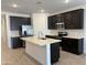 Modern kitchen with dark cabinets, white countertops, stainless steel appliances, and tile backsplash at 18248 W La Senda Dr, Surprise, AZ 85387