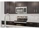 Close up of a kitchen with stainless steel oven, stove and white backsplash at 18248 W La Senda Dr, Surprise, AZ 85387