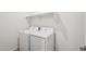 Laundry room with white washer and dryer units under a storage shelf at 18248 W La Senda Dr, Surprise, AZ 85387
