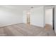 Bedroom with neutral carpet and an open doorway to an adjacent bathroom at 18248 W La Senda Dr, Surprise, AZ 85387