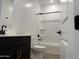 Clean, modern bathroom featuring a black vanity, tub-shower combo and wood-look tile flooring at 18269 W Camino De Oro --, Surprise, AZ 85387