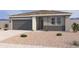 Charming single-story home features a gray exterior, a two-car garage, and low maintenance desert landscaping at 18269 W Camino De Oro --, Surprise, AZ 85387