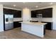 Modern kitchen featuring dark cabinets, stainless steel appliances, a white quartz island and subway tile backsplash at 18269 W Camino De Oro --, Surprise, AZ 85387
