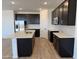 A modern kitchen with stainless steel appliances, dark cabinets, an island, and quartz countertops at 18269 W Camino De Oro --, Surprise, AZ 85387
