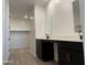 A well-lit bathroom with black cabinets, double sinks, and quartz countertops at 18269 W Camino De Oro --, Surprise, AZ 85387